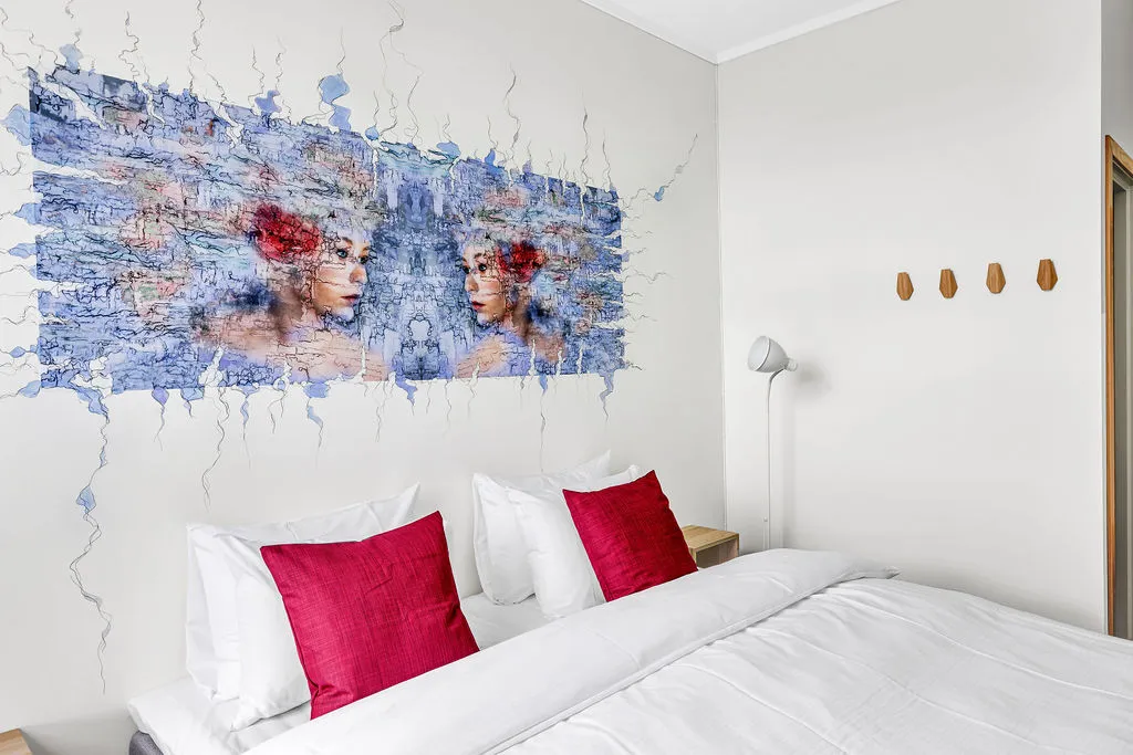 Standard room with colourful art above the bed