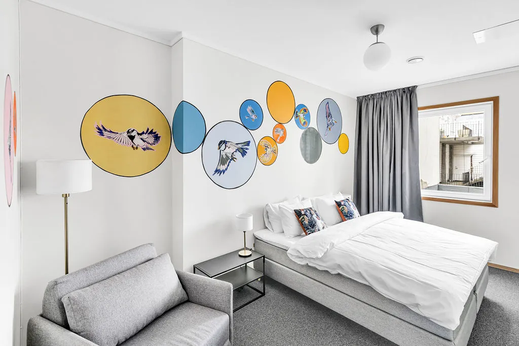 Deluxe room with a double bed and artwork