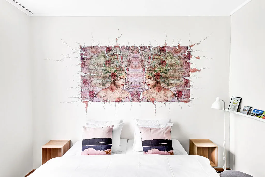 Hotellrom med gatekunst over sengen